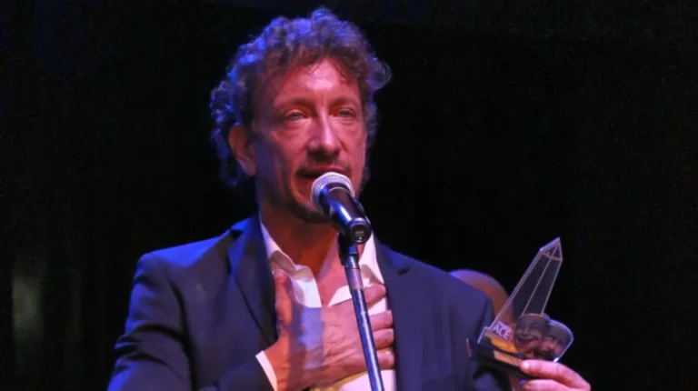 Nico Vázquez sosteniendo el ACE de Oro en el escenario del Teatro Astros durante la ceremonia de los Premios ACE.