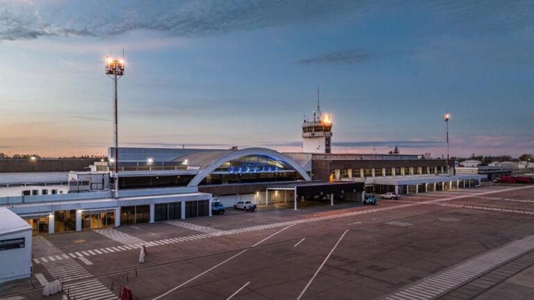 Avión en la pista del Aeropuerto Internacional de Rosario, con cartel indicando destinos Bariloche, Chapelco e Iguazú.