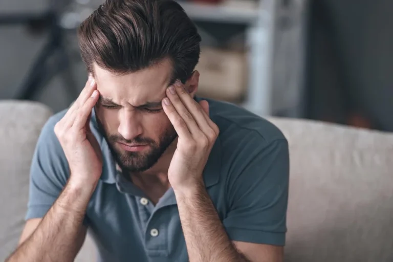 Mujer pensativa tocándose la sien, representando el dolor de cabeza o migraña.