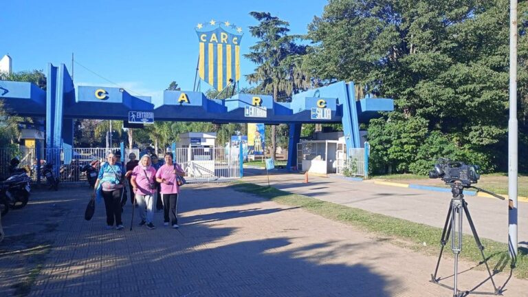 Escudo de Rosario Central con fondo de la Ciudad Deportiva
