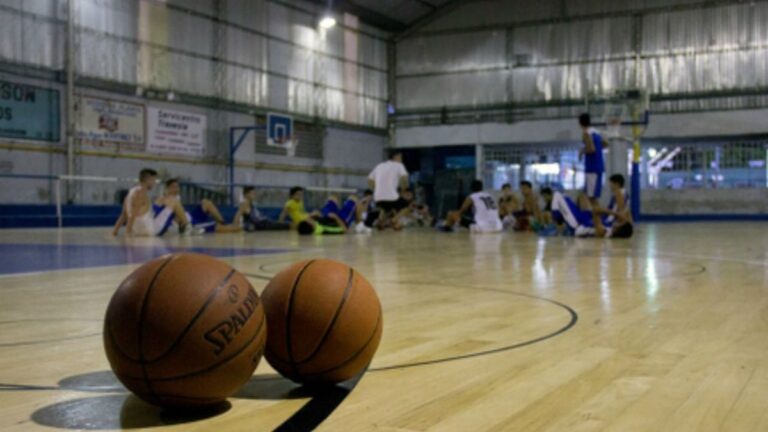 Exterior de un club de barrio en Rosario, con niños y adolescentes realizando actividades deportivas.