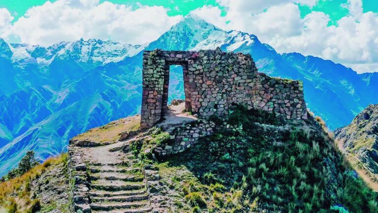 Vista panorámica del Camino del Inca con montañas y ruinas al fondo.