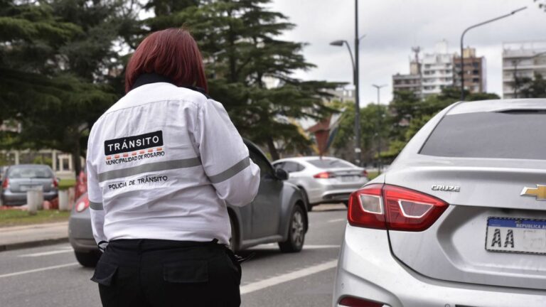 Agente de tránsito en Rosario junto a un cartel de educación vial