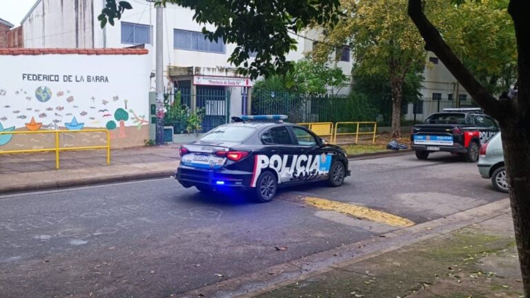Ilustración de una escuela con un símbolo de alerta, representando las amenazas falsas en establecimientos educativos de Santa Fe.