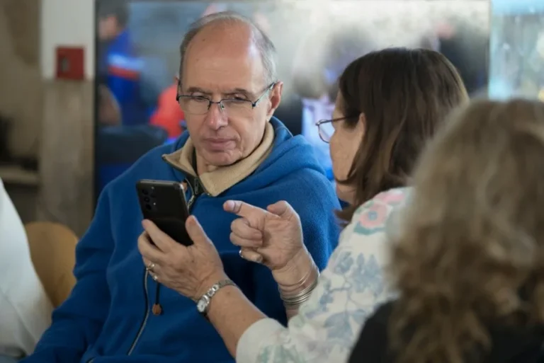 Persona mayor utilizando un teléfono celular en un taller municipal en Rosario